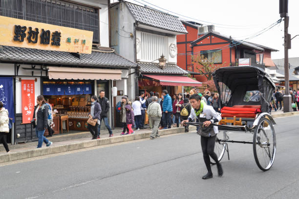 Kyoto, Japan - November 17, 2016: A man draws carriage along the shopping street leads to Togetsukyo Bridge