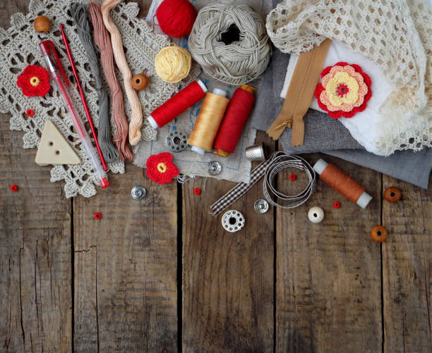 istock Red and grey accessories for needlework on wooden background. Knitting, embroidery, sewing. Small business. Income from hobby. 670953716