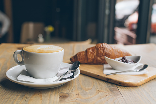 Coffee, Croissant and jam on a wooden table