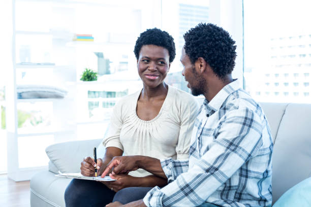 istock Man talking with pregnant wife while pointing on paper 670960248