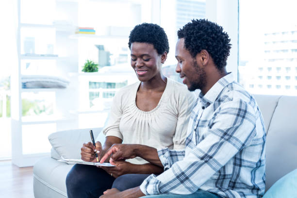 istock Happy man talking with pregnant wife while pointing on paper 670960316