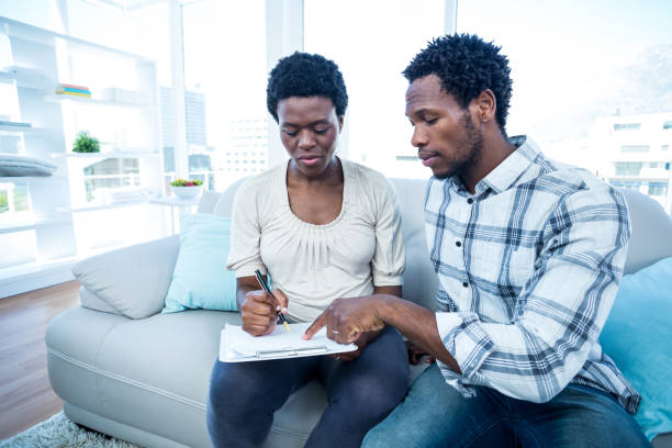 istock Man pointing on notepad while talking with pregnant wife 670960416