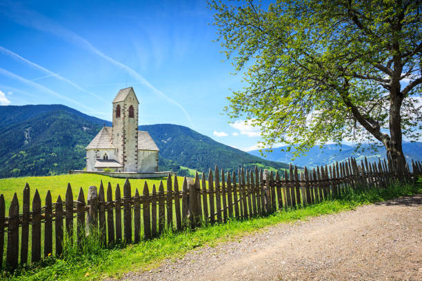 アルペンの風景 - 緑の野原、教会、フェンス、木 - country road fence road dolomites ストックフォトと画像