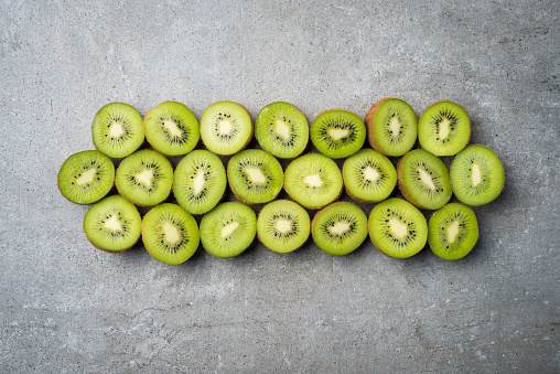 Halves of kiwi fruit on stone background. Close up