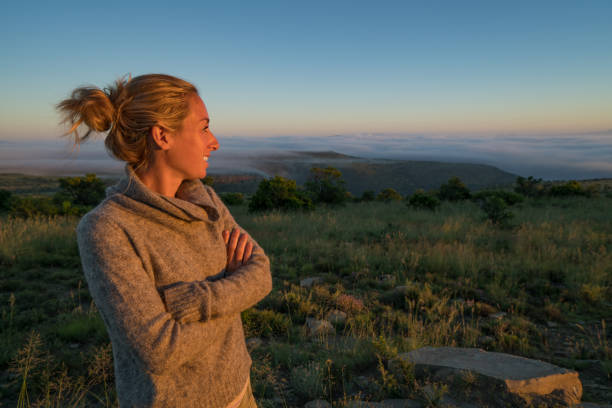 istock Young woman watching sunrise in the savannah 670972376