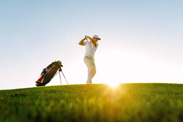 мужской игрок в гольф принимая выстрел на поле для гольфа - golf swing golf teeing off men стоковые фото и изображения