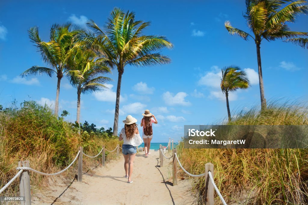 Friends  enjoying time on the beach. Girls walking on the footpath to on the beach on summer vacation. South Beach, Miami, Florida, USA. Miami Stock Photo