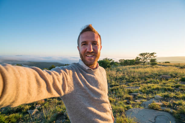 istock Young man taking selfie with mountain landscape 670973824