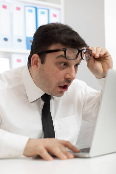 istock Confused businessman looking at his laptop 670974712