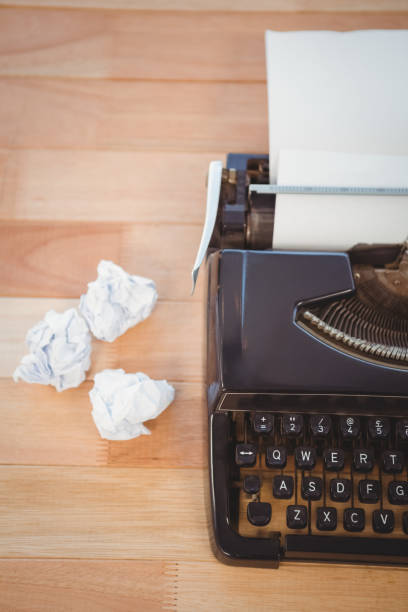 istock Typewriter with crumpled paper on table in office 670974850