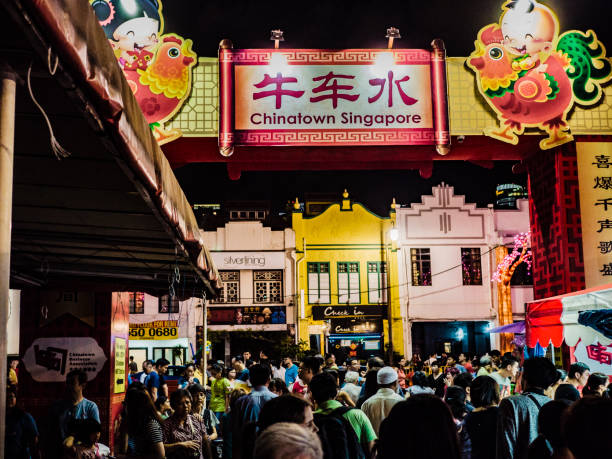 Crowd walking in the streets of Chinatown during the Chinese New Year celebrations in Singapore. Many people celebrate, eat and buy at the many market stalls that open till late at night during this popular celebration.