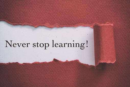 NEVER STOP LEARNING message written under torn paper.