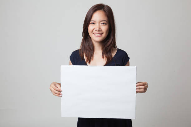 istock Young Asian woman with white blank sign. 670981736