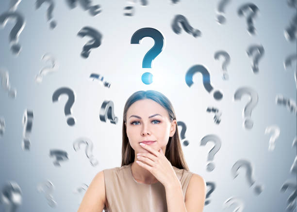 istock Pensive woman in beige and question marks 670982590