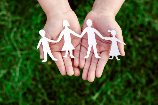 istock four little men in caring hands 670982728
