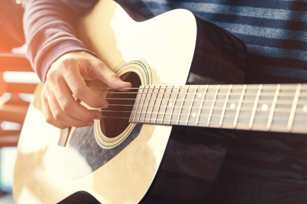 istock Masterclass learning to play the guitar outdoors. Musical education. 670983078
