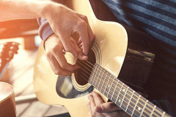 istock Masterclass learning to play the guitar outdoors. Musical education. 670983086