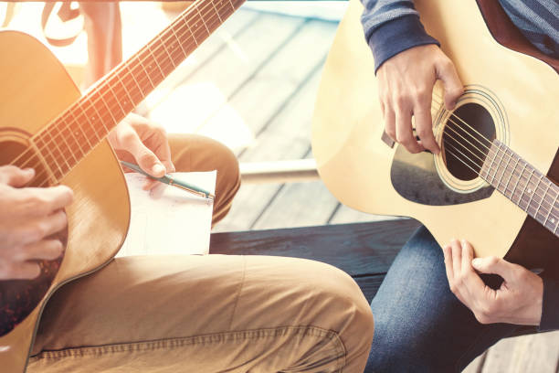 Masterclass learning to play the guitar outdoors. Musical education.