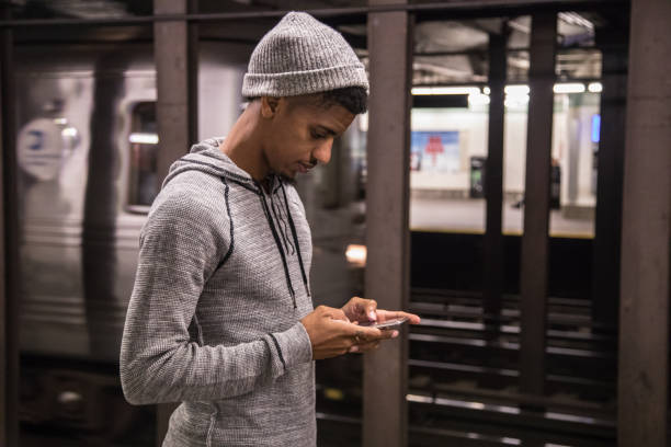 A candid portrait of a young, black man using his phone in New York City. Shot during the autumn of 2016.