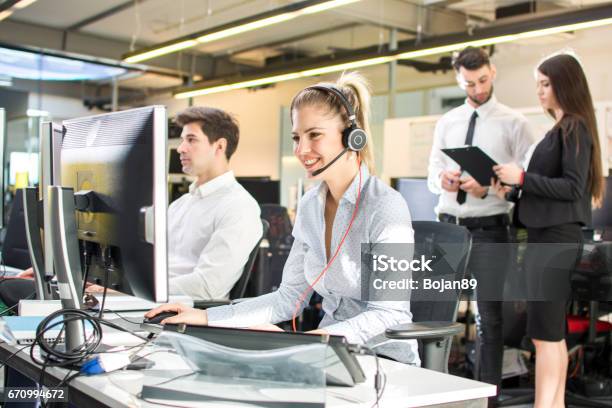 Atractiva Mujer De Negocios Trabajando En Call Center Rodeado De Colegas Soporte En Línea Foto de stock y más banco de imágenes de Centro de llamadas