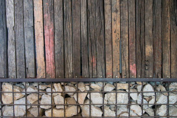 istock Old brown wood and stone in iron net wall texture background pattern 670994776
