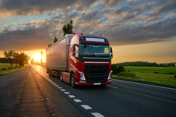 Red truck driving on the road at sunset