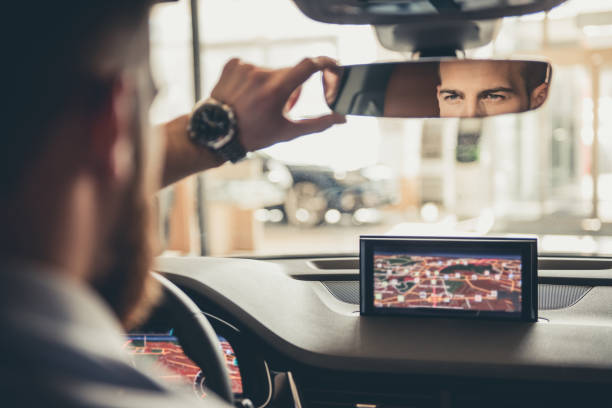 Visiting car dealership Handsome bearded businessman is looking into the rear view mirror while driving the car rear view mirror stock pictures, royalty-free photos & images