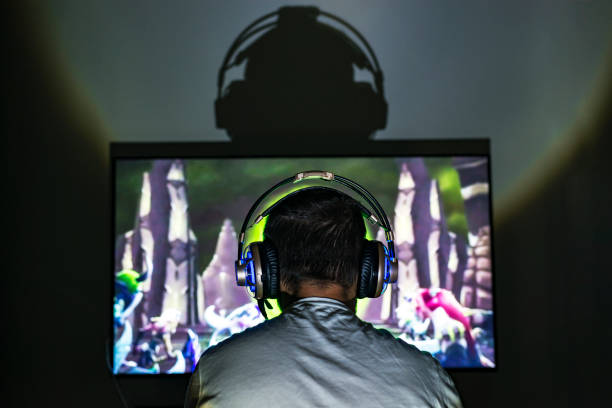 istock Young gamer playing video game wearing headphone. 671014368