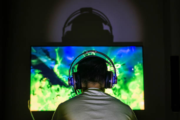 istock Young gamer playing video game wearing headphone. 671014452