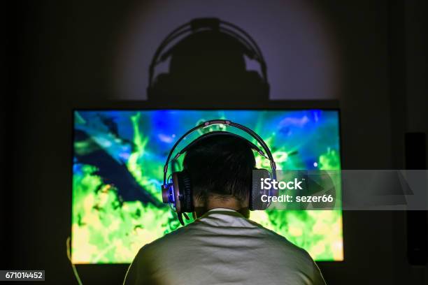 Young Gamer Playing Video Game Wearing Headphone Stock Photo - Download Image Now - Gamer, Headphones, Computer