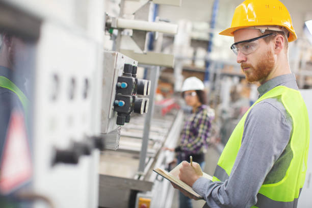 istock Worker in the factory taking readings 671018274