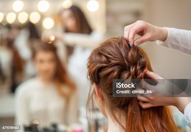 Beautiful Redhaired Girl With Long Hair Hairdresser Weaves A French Braid In A Beauty Salon Stock Photo - Download Image Now