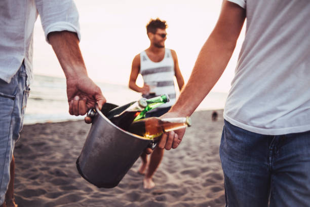 알코올 양동이 들고 소년 - men footprint beach sunset 뉴스 사진 이미지