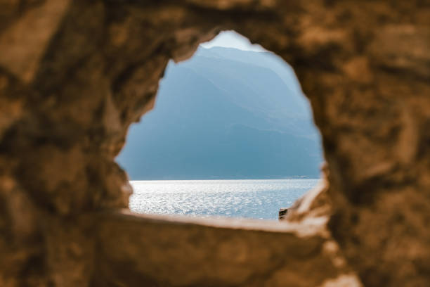 Stone window overlooking scenic landscape Garda lake. Travel background