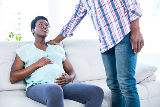 istock Pregnant woman sitting on sofa 671035422