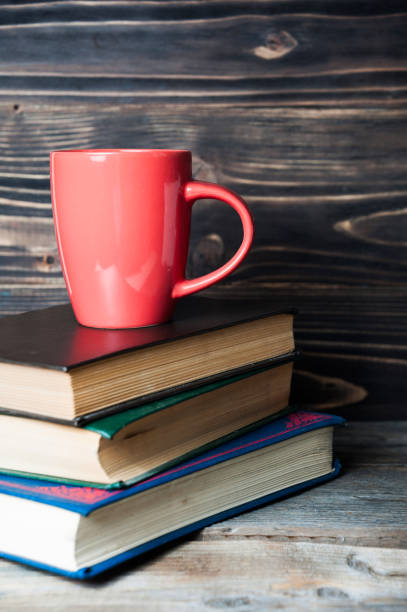 istock Hot coffee or tea, cocoa, chocolate cup on books 671039320