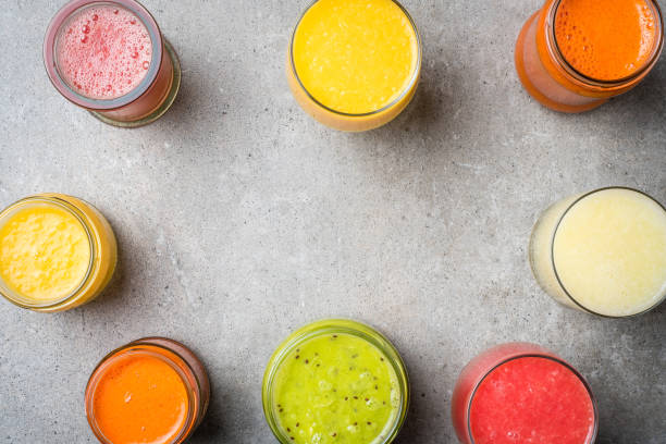 istock Glasses of fresh juice on gray stone table. 671039442