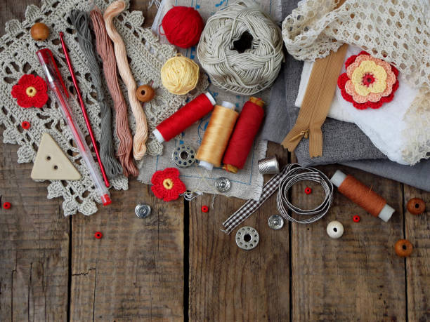istock Red and grey accessories for needlework on wooden background. Knitting, embroidery, sewing. Small business. Income from hobby. 671041710