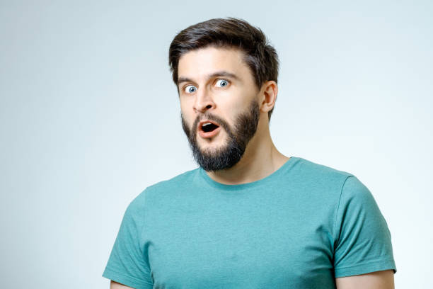 istock Handsome man posing with amazement isolated on gray 671050498