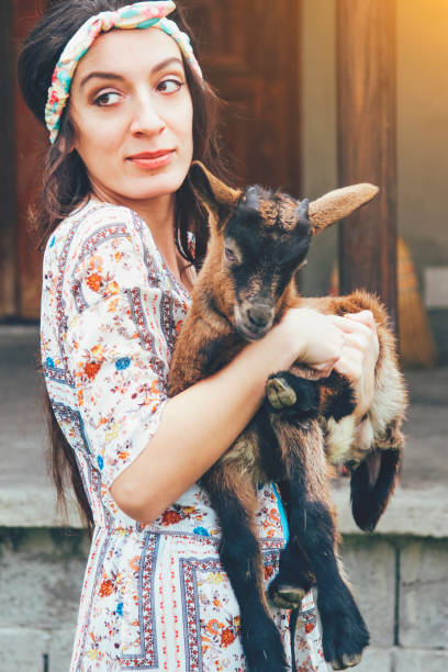 istock Cute brunette holding a little goat 671050716