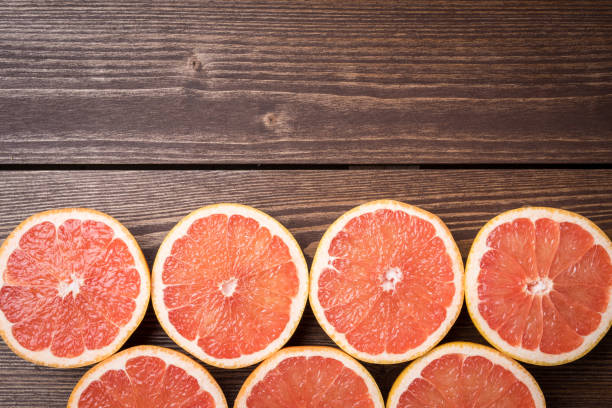 istock Grapefruits on wooden table. Food background 671050926
