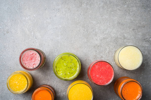 istock Glasses of fresh juice on gray stone table. 671053886