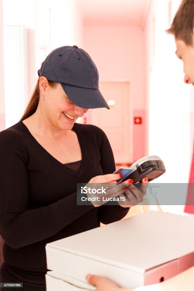 Payment of the pizza by ATM Pizza is paid by ATM card - 
 Adult Stock Photo
