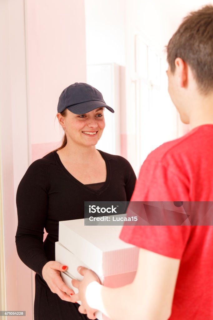 Young woman delivers pizza Female person hands over the pizza -
 Adult Stock Photo