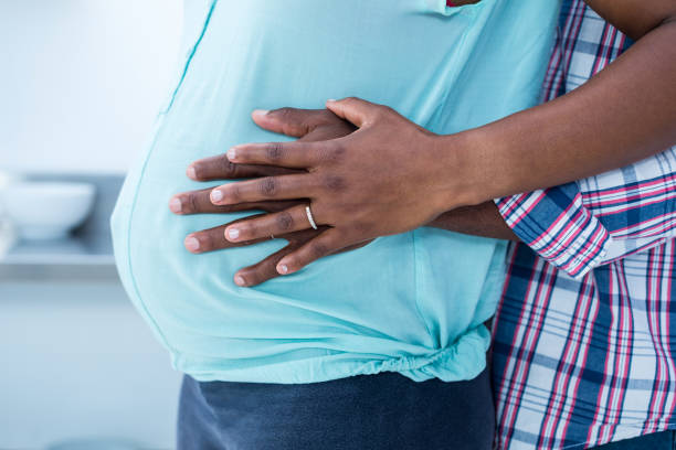 istock Mid section of man embracing his wife 671054360