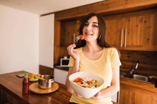 istock woman eating a vegetable 671058308
