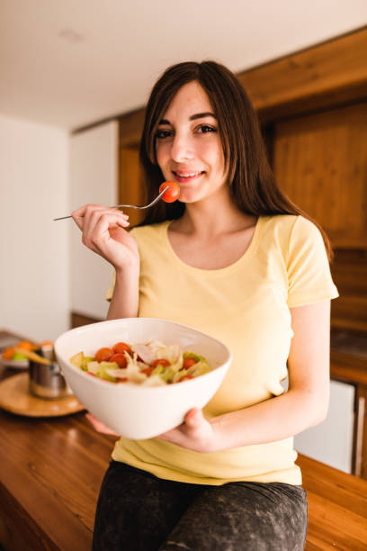 istock woman eating a vegetable 671058462