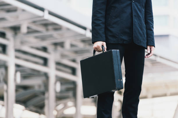 istock Businessman holding his briefcase in city 671059590