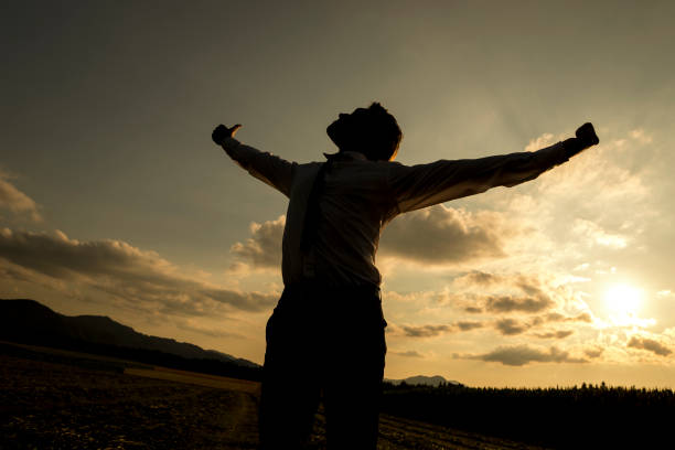 istock Person with spread arms in countryside sunset 671065024