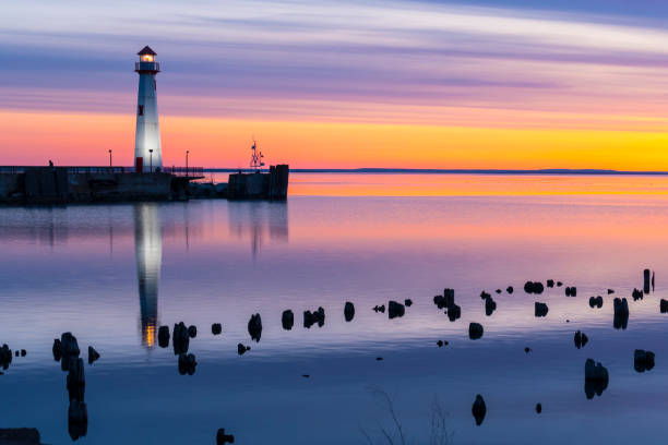 istock Scenic Lighthouse in calm waters, colorful predawn light. 671065846